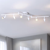 Track lighting fixture on a ceiling with four lights on a white ceiling.